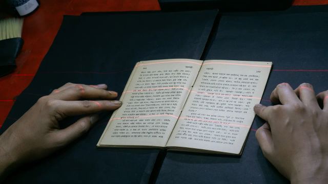 زائر يتصفح كتاباً في أحد أجنحة العرض بشارع المتنبي (الفرات)