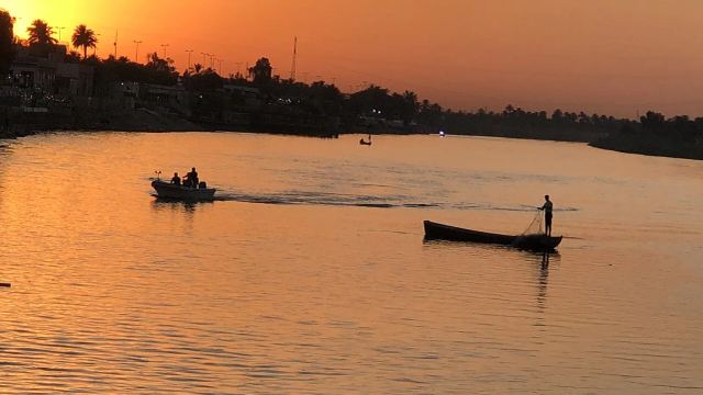 زورقان في نهر الفرات عند الغروب، وهو أحد مصادر تغذية الأهوار في الجنوب. صورة أرشيفية